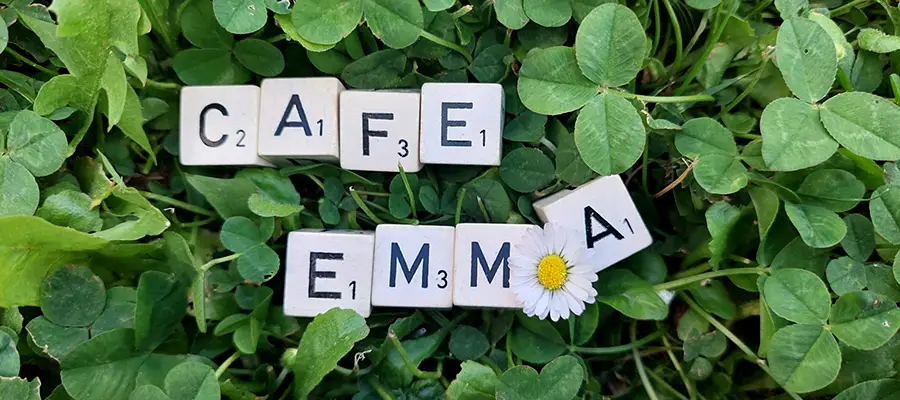 Café EMmA - Schriftzug mit Würfel auf Kleeblätter
